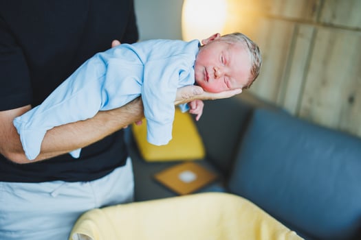 Newborn baby boy in his father's arms, lying on his arms close-up top view. A man is holding a small child. Healthy Lifestyle. Paternity photo