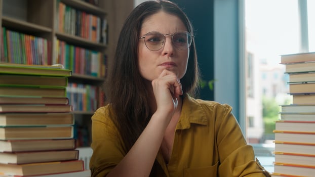 Pensive female thoughtful woman girl high school student teacher tutor thinking pondering education class studying learning prepare for exam seminar in library learn books college academy university photo