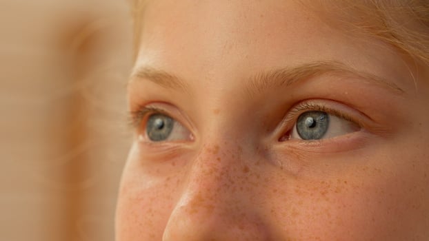 Close up girl little child face Caucasian kid with blue eyes looking at camera innocent teen happy adopted daughter ginger schoolgirl female school student smiling healthcare sport event soap bubbles photo