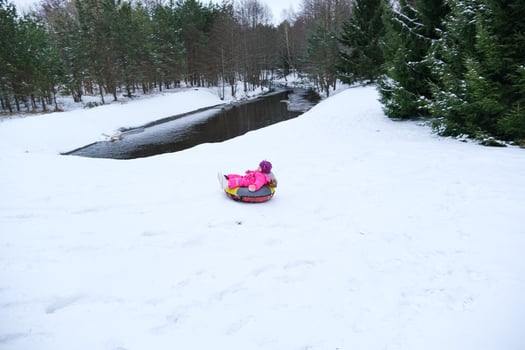 A child rides a tube down the mountain photo