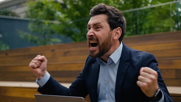 Annoyed mad angry man Caucasian businessman furious business leader work remote laptop city outdoors male guy talk mobile phone quarrel shout fight scream conflict finish call throwing cellphone away photo