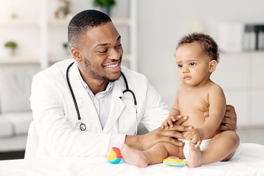 Medical Care For Babies. Smiling Black Pediatrician Making Health Check Up For Little Baby Patient In Clinic, Friendly African American Doctor Having Appointment With Cute Infant Child, Closeup photo