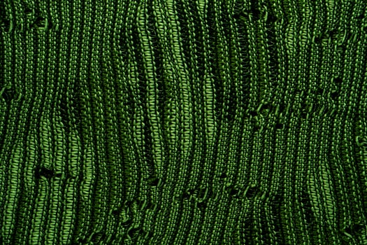 A close-up of green knitted fabric texture, detailed pattern, and vibrant color, suitable for backgrounds. photo
