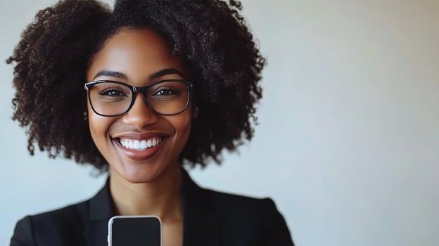 A woman with glasses and a black suit holding a cell phone photo