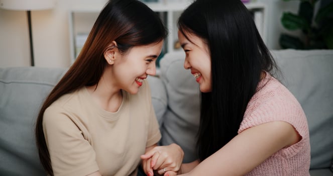 Portrait of Lesbian couple talking and sharing moments of love and happiness together on the sofa in the living room at home. LGBTQ Lifestyle. photo