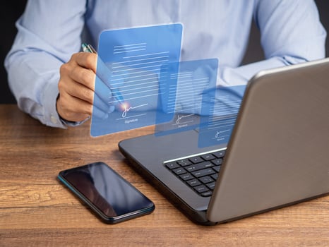 A businesswoman uses a pen to sign electronic documents on digital documents on a virtual screen photo