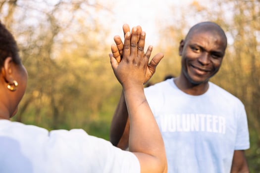 African american volunteers doing high five praising each other after a successful environmental mission, finishing junk and plastic cleanup. Joyful activists enjoying their job well done. photo