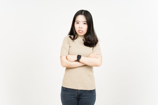 A woman in a tan shirt and jeans standing with her arms crossed photo