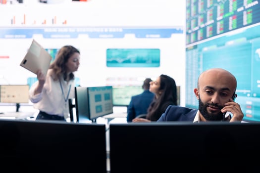 Chief executive officer reviewing project details about achieving business goals, establishing resource allocation. Administrator works in a firm monitoring room with big screen. photo