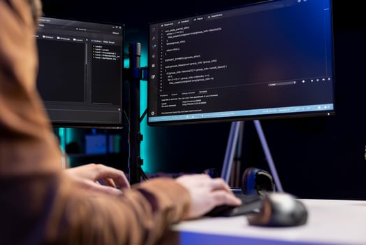 Teleworking cybersecurity administrator using computer to look for security vulnerabilities. IT technician typing on keyboard, installing safeguard code on PC to prevent cyber attacks, close up photo