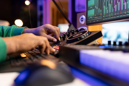 Skilled artist audio engineer mixing and mastering tracks on stereo console, operating with professional post production gear in home studio. Musician producing sounds for performance. Close up. photo