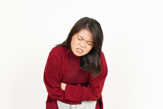 Stomachache Gesture Of Beautiful Asian Woman Wearing Red Shirt Isolated On White Background photo