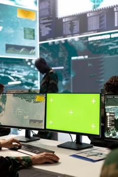 Trooper following CCTV satellite surveillance on pc next to isolated mockup screen, tracking deployed units with GPS location. Army conscript operating in command post headquarters. photo