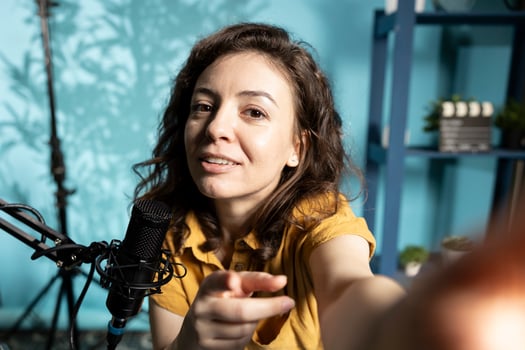 ASMR artist using quality mic and smartphone selfie camera in studio to do anti stress , whispering tingling sounds. Woman using microphone and mobile phone to film sleep inducing content photo