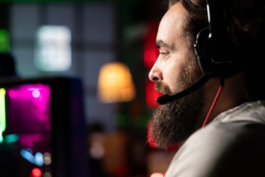 Player plays first person shooter videogame with internet teammates, discussing strategy to defeat flying robots. Close up of gamer talking with friends in competitive PvP fps multiplayer game photo