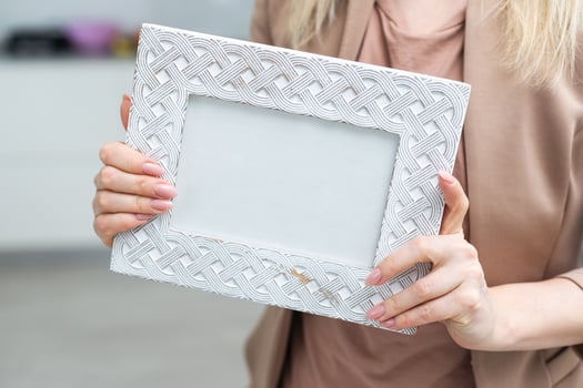 White photo frame in hand on white background. Isolation
