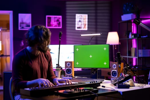 Sound engineer hitting electronic piano notes and following tutorials on pc with greenscreen, recording a melody on midi controller keyboard. Beginner musician using synthesizer keys. photo