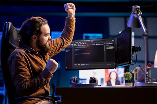 Ecstatic cybersecurity specialist celebrating after finding security vulnerabilities and preventing malware infections. Excited programmer delighted about preventing cyberattacks photo