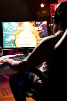 Upset gamer having to restart game from beginning after losing mission while playing spaceship videogame. Player feeling gutted after getting flying spacecraft destroyed by more powerful enemies photo