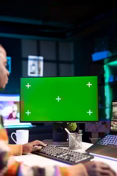 Videographer creating visual effects on montage next to green screen, working on color correction to edit footage and frames. Freelancer content creator editing clips on computer software. photo