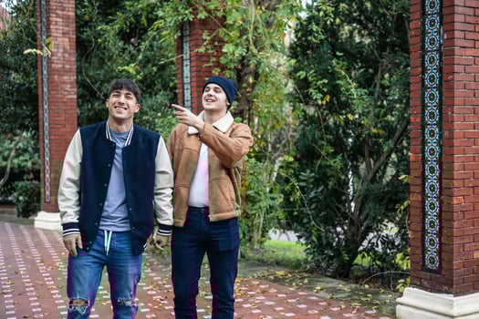 young boyfriends walking holding hands pointing up photo