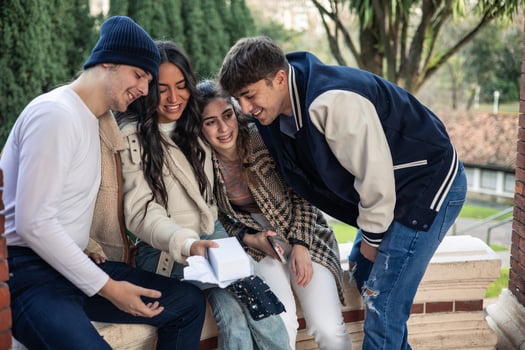 group of multiethnic friends hugging after receiving gift photo