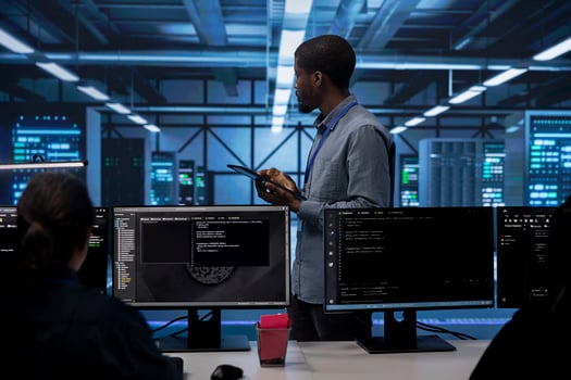 Admin in data center using tablet to check for server performance issues arising due to high CPU usage. Server room employee fixing insufficient memory errors slowing down hardware photo