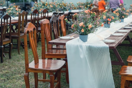 Rustic wedding style, Wooden dining table with flowers decoration and tableware photo