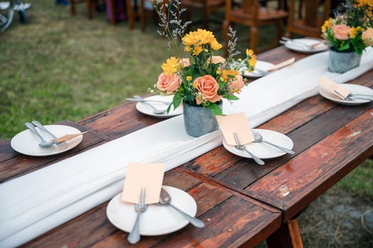 Rustic wedding style, Wooden dining table with flowers decoration and tableware photo