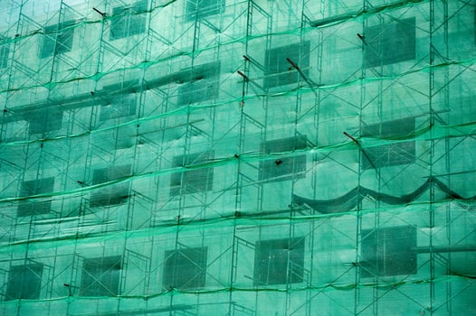 Building structure with green netting shade and scaffolding photo