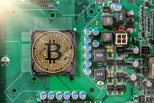 Gold souvenir coin Bitcoin on a computer circuit board background. photo