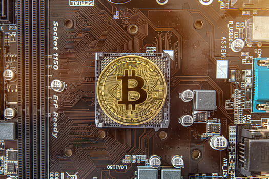 Gold souvenir coin Bitcoin on a computer circuit board background. photo