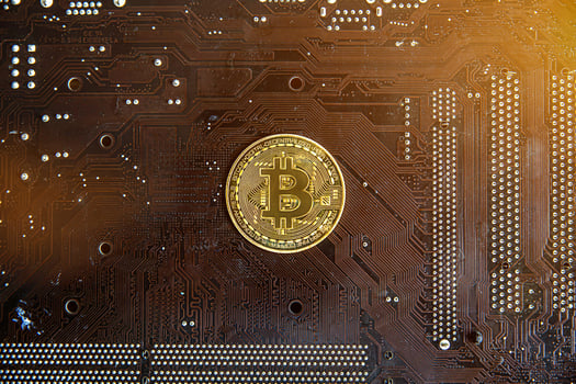 Gold souvenir coin Bitcoin on a computer circuit board background. photo
