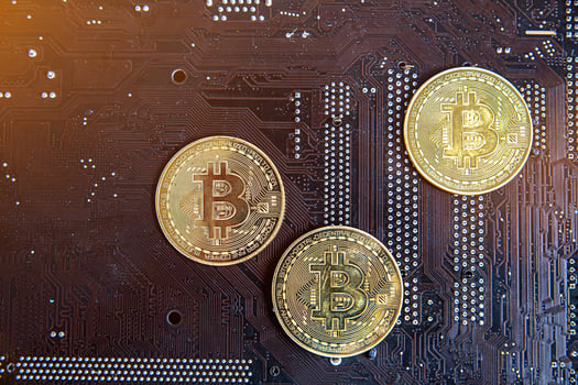 Gold souvenir coin Bitcoin on a computer circuit board background. photo