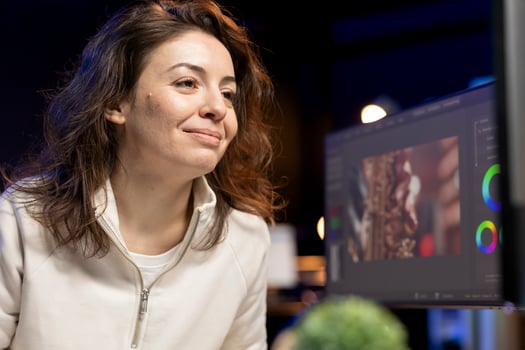 Happy videographer using professional software to create visual effects for projects. Smiling expert using post production techniques to edit raw clips footage in home office photo