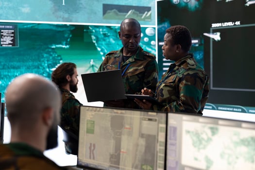 Female infantry unit soldier and new recruit discuss about mission details, gathering intelligence via radar surveillance on a big screen. National guard protection with a world map. photo