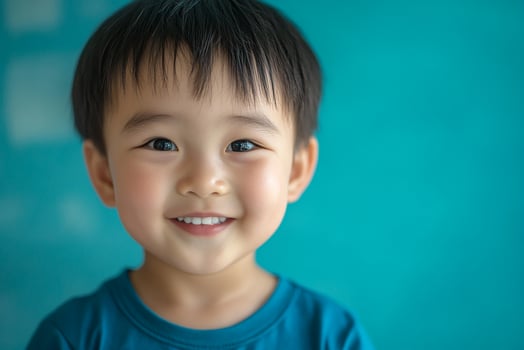 A young boy is smiling and looking at the camera photo