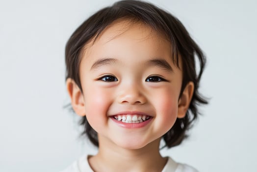 A little asian boy smiling and looking at the camera photo