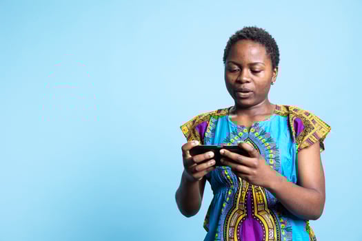 African american model playing online cyber sport competition, having fun with gaming tournament on smartphone app. Woman enjoying mobile games play, virtual championship. photo