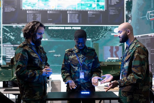 Team of diverse troopers collecting intelligence in a power base, studying CCTV footage on a hologram projection to aid infantry units in the field. Trained soldiers study real time data. photo