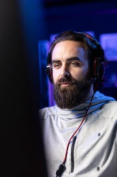 Man playing videogames in front of subscribers during livestream, focused on defeating enemies. Close up on pro gamer streaming game, wearing headphones, doing online stream photo