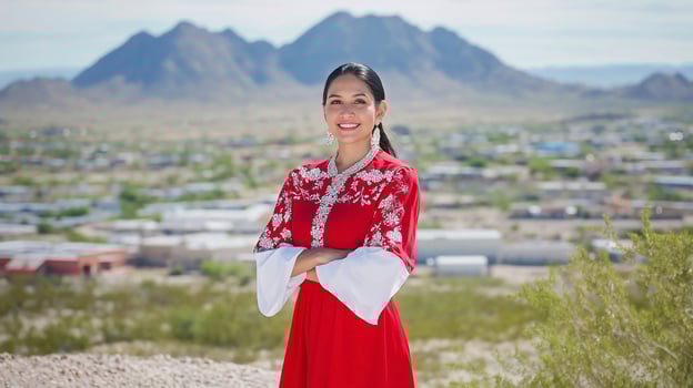 Portrait of Native American woman in traditional attire against desert landscape photo