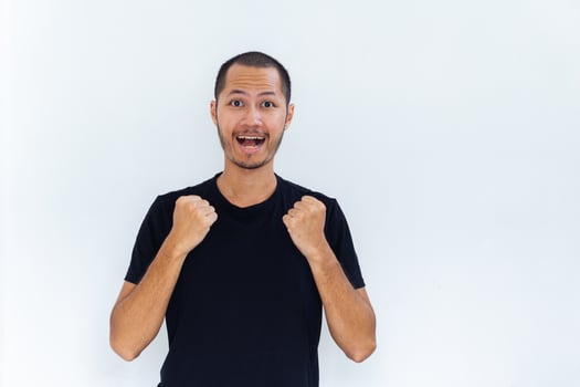 Young men is posing winning gesture with palm fist hand with black shirt on isolated white background photo