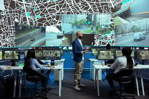 Middle eastern supervisor gives instructions to his team in control center, pointing at satellite navigation and CCTV surveillance to guide delivery couriers on their way to the destination. photo