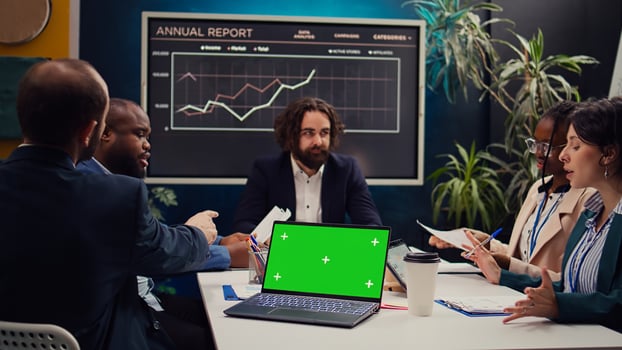 Business partners attending meeting next to greenscreen laptop, discussing the fate of the global enterprise and working on developing financial resources. Startup team address daily issues. Camera B. photo