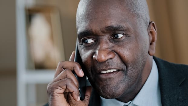 Close-up emotional old 50s wrinkled male face friendly businessman talking phone mobile conversation call answering. Portrait African man boss leader smartphone ordering chatting speaking negotiation photo