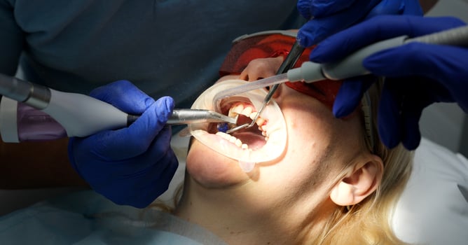 Orthodontist doctor examine tooth to woman patient at dental clinic. Attractive young girl with braces lying on dental chair, getting dental treatment from dentist during procedure service in hospital photo