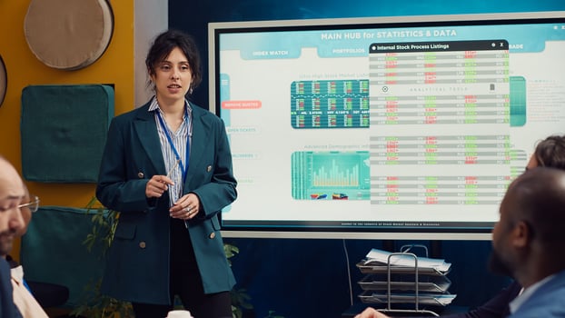 Marketing specialist evaluating market trends by studying infographics with her coworkers in a corporate briefing. Manager planning campaigns and promotional activities to increase sales. Camera A. photo