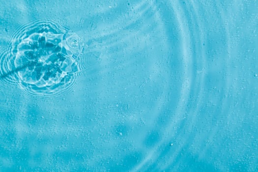 drops on water with circles on a blue background photo