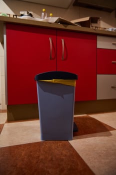 Kitchen garbage bin in a clean modern kitchen with red cabinets photo